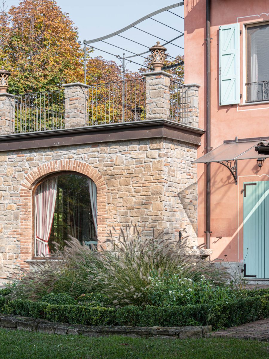 Casa padronale della tenuta equestre con bordura dry garden formale di Ilex crenata, graminacee e perenni.